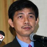 Close up of Tran Huynh Duy Thuc at a podium with a microphone